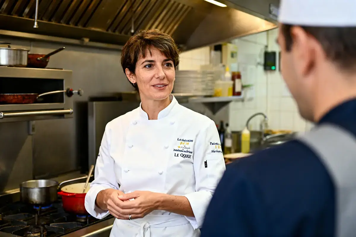 Stéphanie Le Quellec échange avec un collègue dans une cuisine professionnelle active et équipée