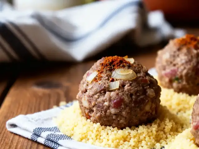 Boulettes pour couscous sur lit de semoule garnies d'oignons et paprika