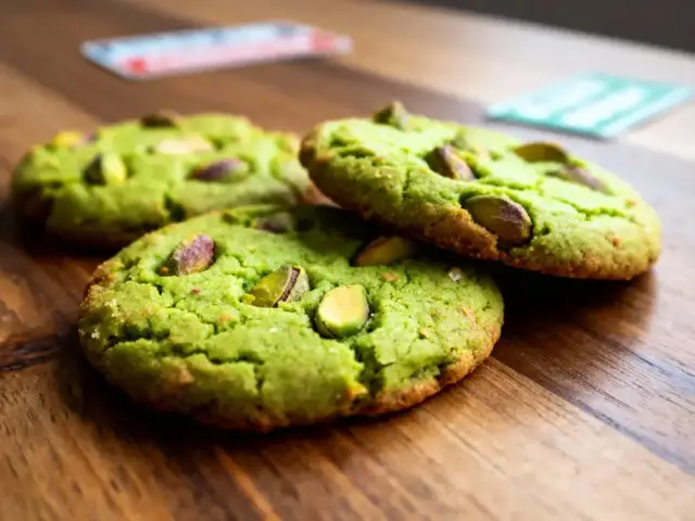 Cookies verts aux pistaches sur table en bois, éclairage naturel.
