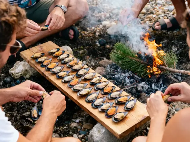 Personnes cuisinant des moules sur planche en bois près d'un feu de camp, entourées de pierres.