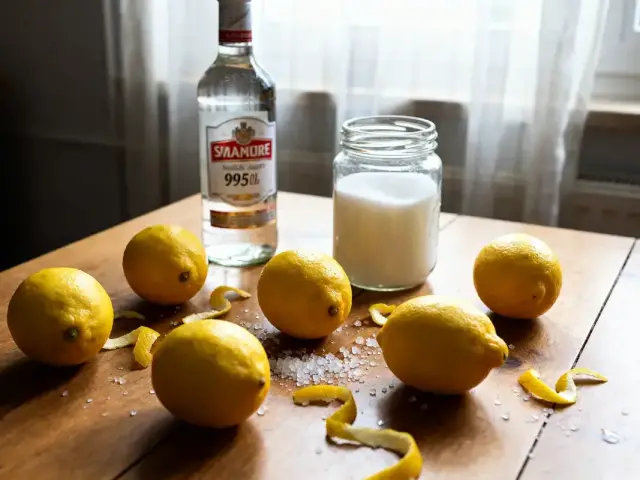 Citron, sucre, alcool sur table pour recette de limoncello maison et authentique