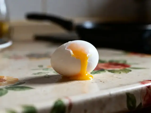 Œuf à la coque coulant sur table suggérant le temps d'un oeuf à la coque parfait